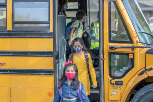 istock Masked school children getting off the bus 1277410023