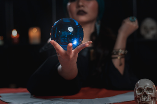 Mysterious beautiful woman fortune teller holding magical crystal ball