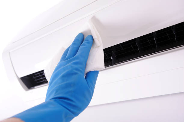 especialista limpia y repara el aire acondicionado de la pared - furnace lighting technique air conditioner repairing fotografías e imágenes de stock