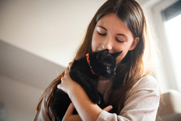 istock Young woman with her cat at home relaxing 1277412947