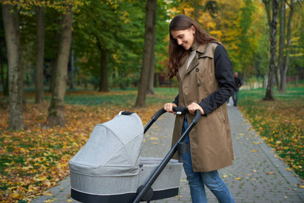 istock Woman in grey coat standing with baby stroller. 1277413174