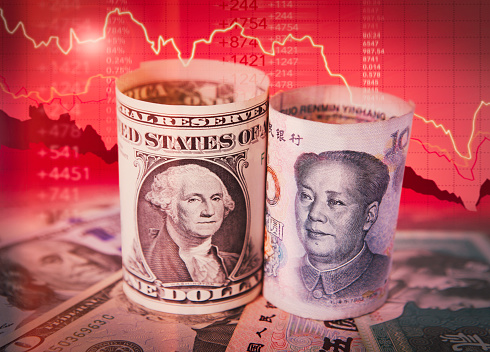 US dollar and Chinese yuan (Renminbi) banknote with red chart on the background