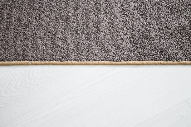 The carpet rolled into a roll with overlock lies on the white floor.