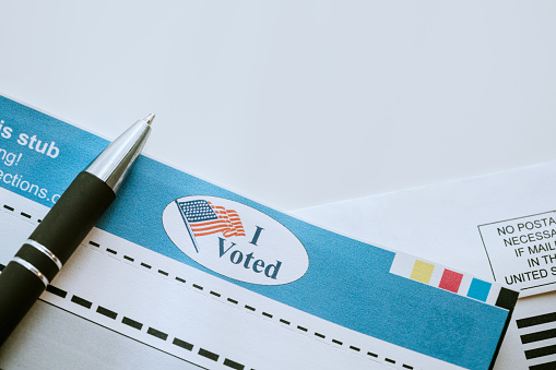 A close up image of a voters ballot to be mailed in, a pen ready to fill in the selected votes.