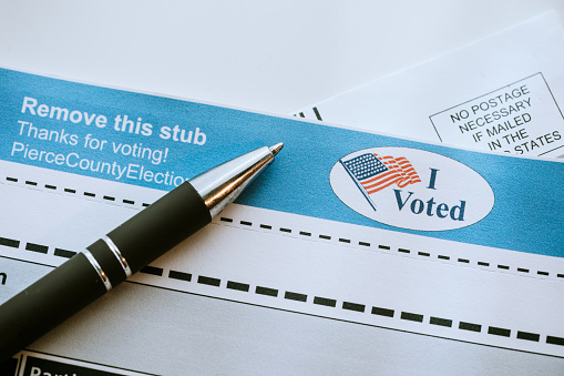 A close up image of a voters ballot to be mailed in, a pen ready to fill in the selected votes.