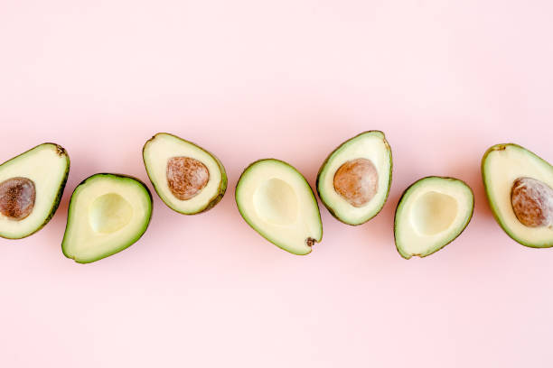 Avocado on pink background. Tropical abstract background with avocado. Food concept. flat lay, top view