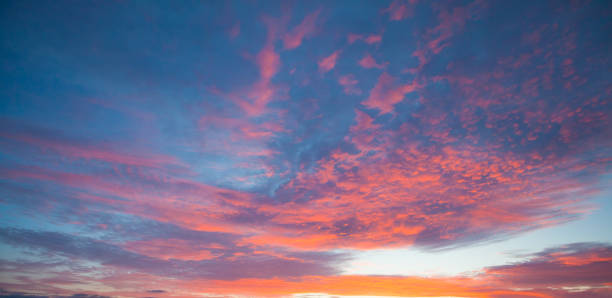 istock Red and blue sunset sky with clouds and sun 1277419833