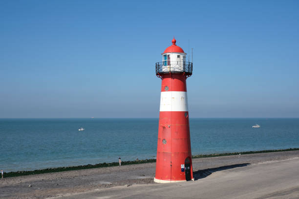 istock Red and white lighthouse on a blue sky background, Westkapelle, The Netherlands 1277421220