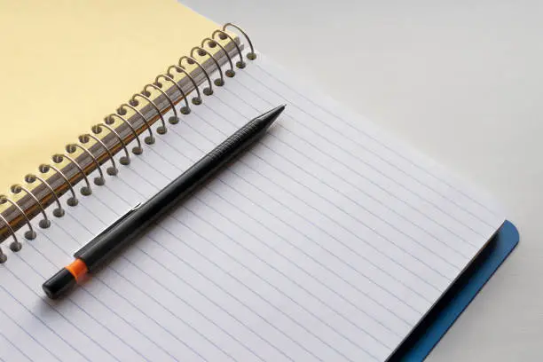 Open spiral notebook and black pencil. Copy space for text. Education background.