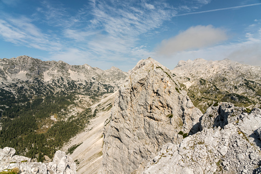Beautiful view on top of the mountain in Julian Alps in Triglav national Park. Two person standing on top.  Slovenia