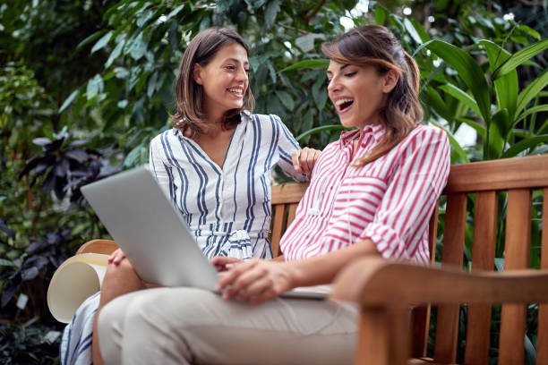 istock Young female students excited about watching laptop content in a botanical garden 1277423256