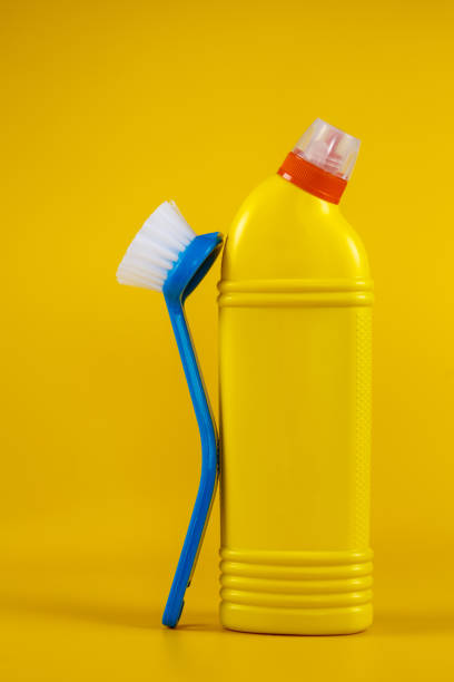 istock Bottle with detergent powder and brushes on yellow background, space for text 1277424719