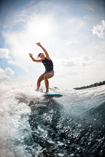 istock woman balancing on the wake board on high wave against blue sky 1277425612