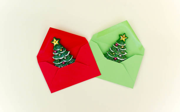 istock flat lay of red envelop with Christmas tree inside on light yellow background. Concept of presents and surprise for family. Christmas mood. Free copy space. 1277425863