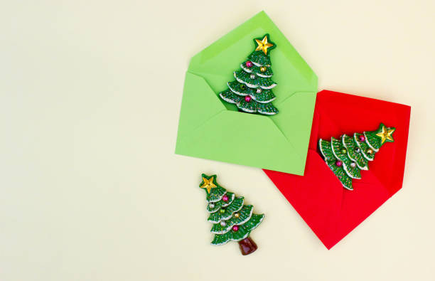 istock flat lay of red envelop with Christmas tree inside on light yellow background. Concept of presents and surprise for family. Christmas mood. Free copy space. 1277425878