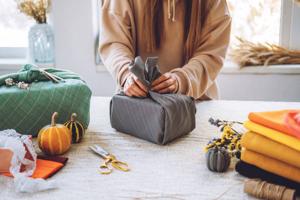 istock Furoshiki Japanese Gift Wrapping. Thanksgiving Zero waste, eco-friendly gift wrapping process, tutorial. Fall hand-wrapped gift in traditional Japanese Furoshiki style 1277426702