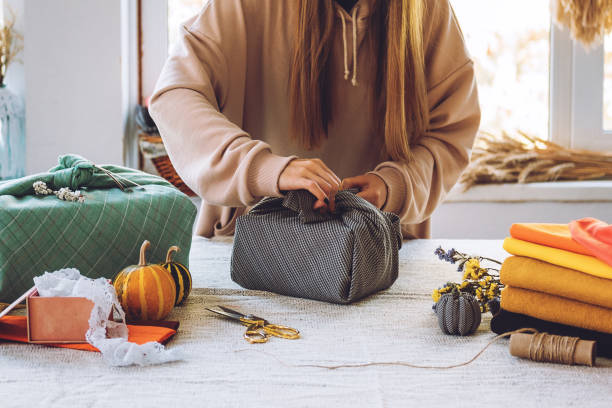 istock Furoshiki Japanese Gift Wrapping. Thanksgiving Zero waste, eco-friendly gift wrapping process, tutorial. Fall hand-wrapped gift in traditional Japanese Furoshiki style 1277426704