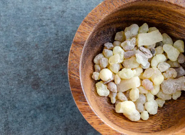 Overhead view of Frankincense tears or resin in wooden bowl.  Horizontal composition with copy space for text.