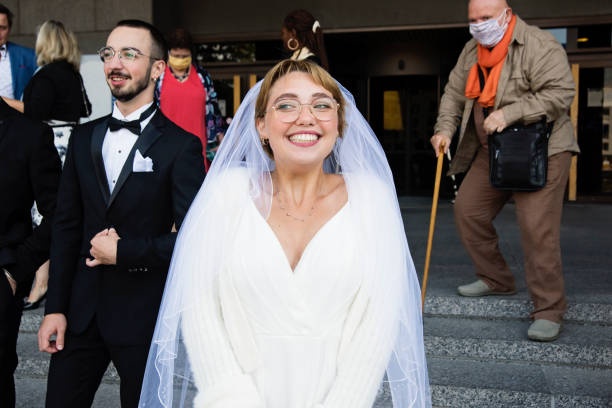 istock Newlyweds and guests leaving courthouse after wedding during Covid. 1277432392