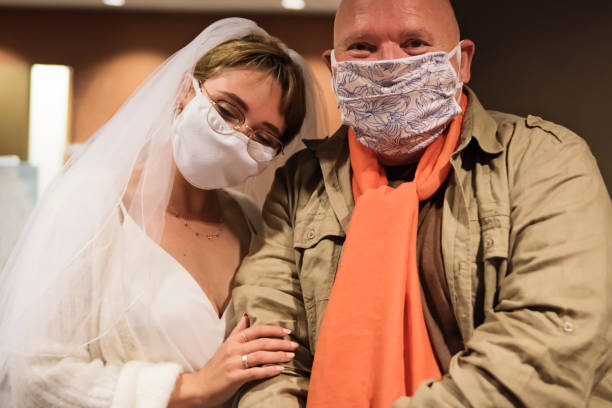 Bride and godfather wearing face masks for wedding during Covid.