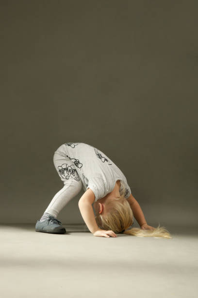 istock Tree years old toddler girl learning to roll forward, studio shot 1277434612