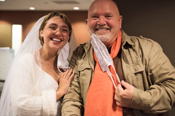 istock Bride and godfather putting down face masks for portrait during Covid. 1277434616