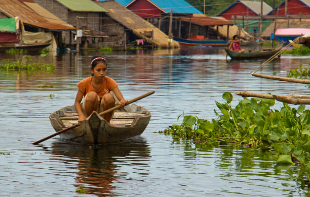 Tonle Sap Lake, Cambodia - Oct 14, 2011: Girl rowing her boat to school