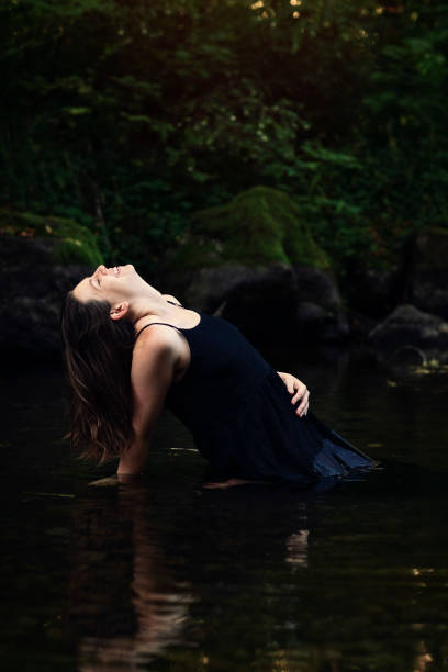 istock Woman sitting in water looking up 1277439635