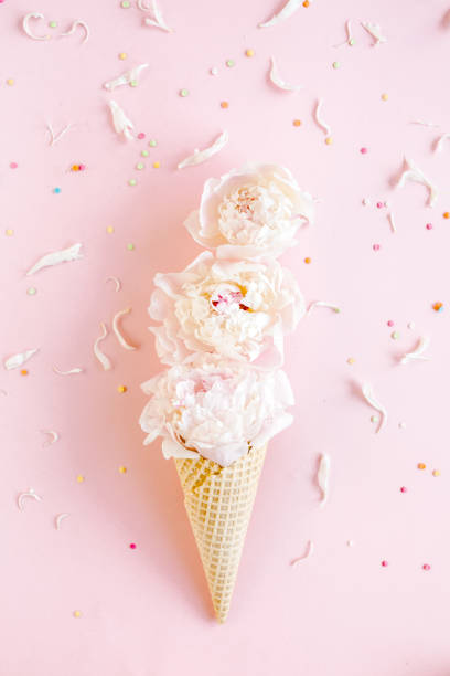 istock Waffle cone with peonies flower on pink background. Flat lay, top view floral background 1277445524
