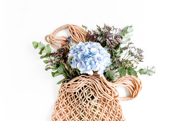 istock Beautiful bouquet of hydrangeas in a string, eco bag on white background. Flat lay, top view 1277447441
