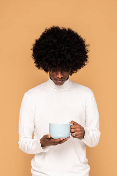 un tipo afro sosteniendo una taza de café. - 18827 fotografías e imágenes de stock