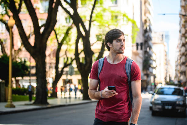 istock Male Tourist Pausing to Check Directions on Smart Phone 1277452267