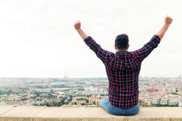 istock man on the rooftop looking the city with arms up 1277453470