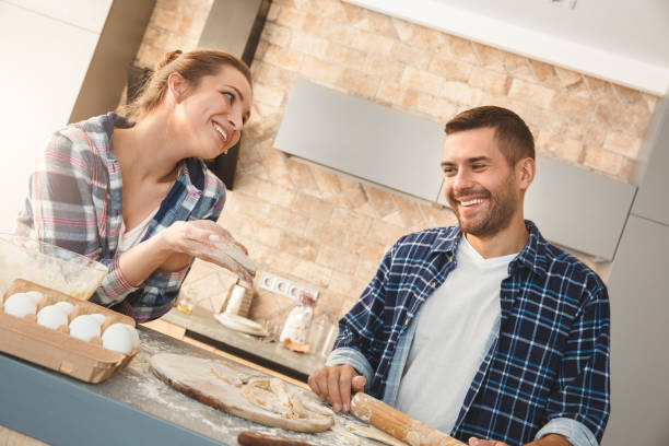 istock Couple at home standing in kitchen making pastry together smiling joyful 1277453650
