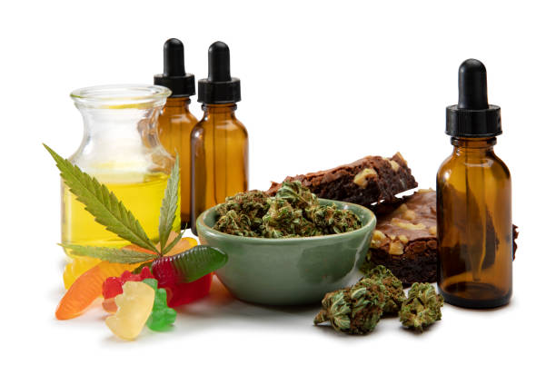 huiles de cannabis et bourgeon dans un petit bol entouré de comestibles sucrés - haschisch photos et images de collection