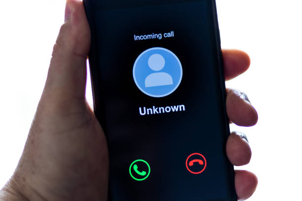 istock Man holding cell phone receiving unknown call - Background with computer screen and blue neon light with lilac 1277457749
