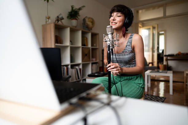 istock Female singer singing and recording her new song in the music studio 1277458474
