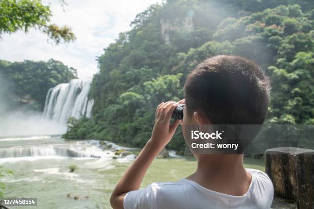 Cute Boy Looking At Waterfall With Binoculars Stock Photo - Download Image Now - Asia, Boys, Vacations