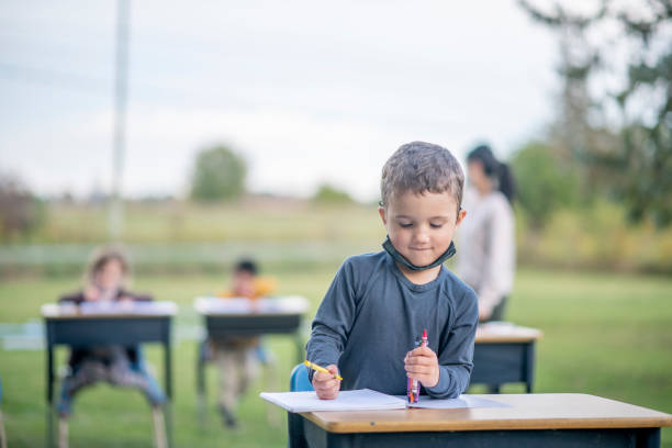 istock Students sit at desks outside in a modified classroom during the COVID-19 pandemic 1277458591