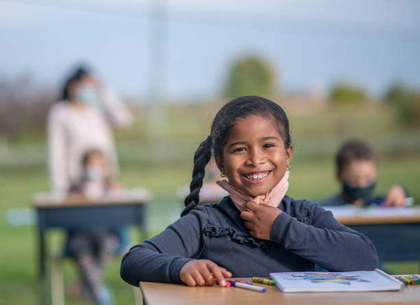 istock Students sit at desks outside in a modified classroom during the COVID-19 pandemic 1277458597