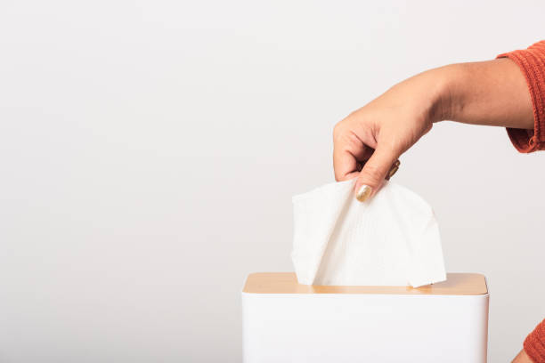 istock Hand taking pulling white facial tissue out of from a white box 1277468214