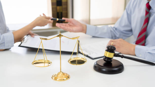 istock Client with his partner lawyers or attorneys discussing discussing a document or contract agreement working at table in office, Good service cooperation 1277468892