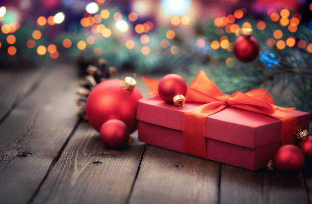 istock Red gift box with christmas decorations on defocused lights in Background 1277470718