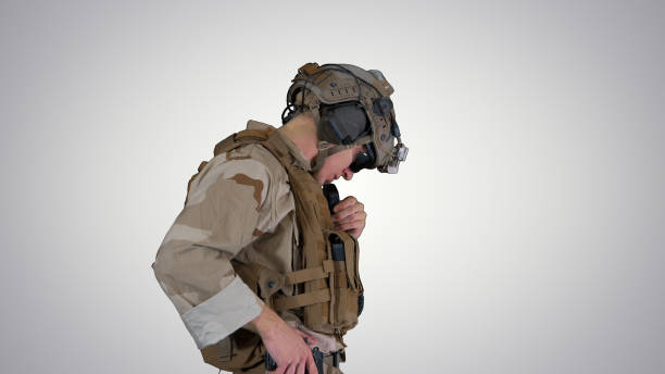 istock Soldier standing and talking on the radio on gradient background 1277473332