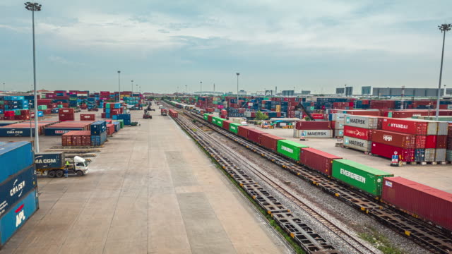 4K Time lapse or Hyper lapse : Busy traffic in Container Cargo Warehouse at Terminal Commercial Port with Mobile Crane Truck loading container to the Freight Train, Business Logistics import export  shipping or Freight Transportation.