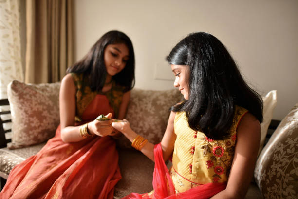istock Elder sister making henna on younger sister’s hand 1277474807