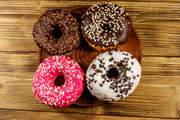 istock Tasty donuts on a wooden table. Top view 1277476594