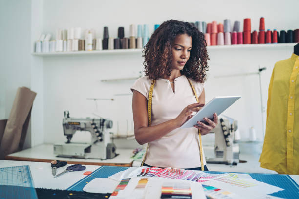 designer with a digital tablet - manual worker sewing women tailor imagens e fotografias de stock