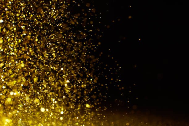 istock Sparkling golden glittering effect isolated on black background. 1277478939