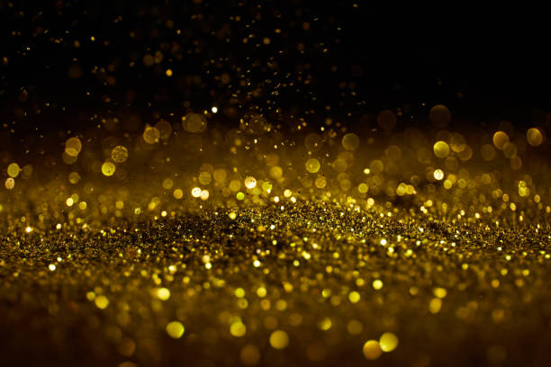 istock Sparkling golden glittering effect isolated on black background. 1277478947